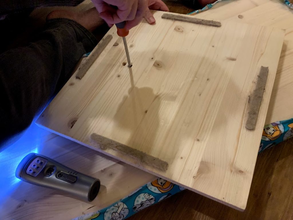 Screwing the baseboard onto the long board through the drilled hole to make sensory spinning full body toy for kids. 